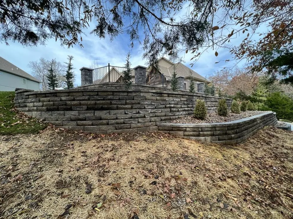 Tiered stone retaining wall stepping up a landscaped slope
