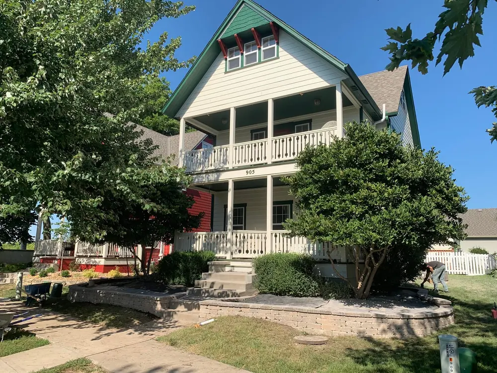 Two-story home with a fresh green lawn, driveway and tidy landscape beds